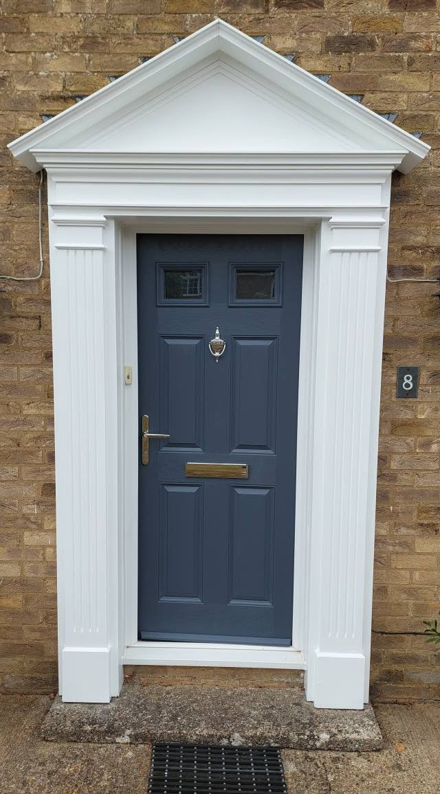 Grey-blue front door in a white pedimented surround