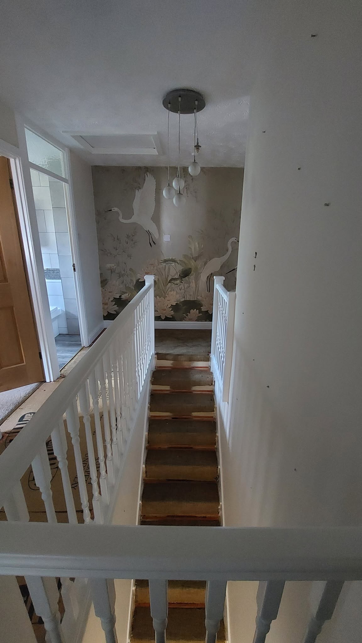 Landing and stairs seen from above, white balustrade and feature wallpaper