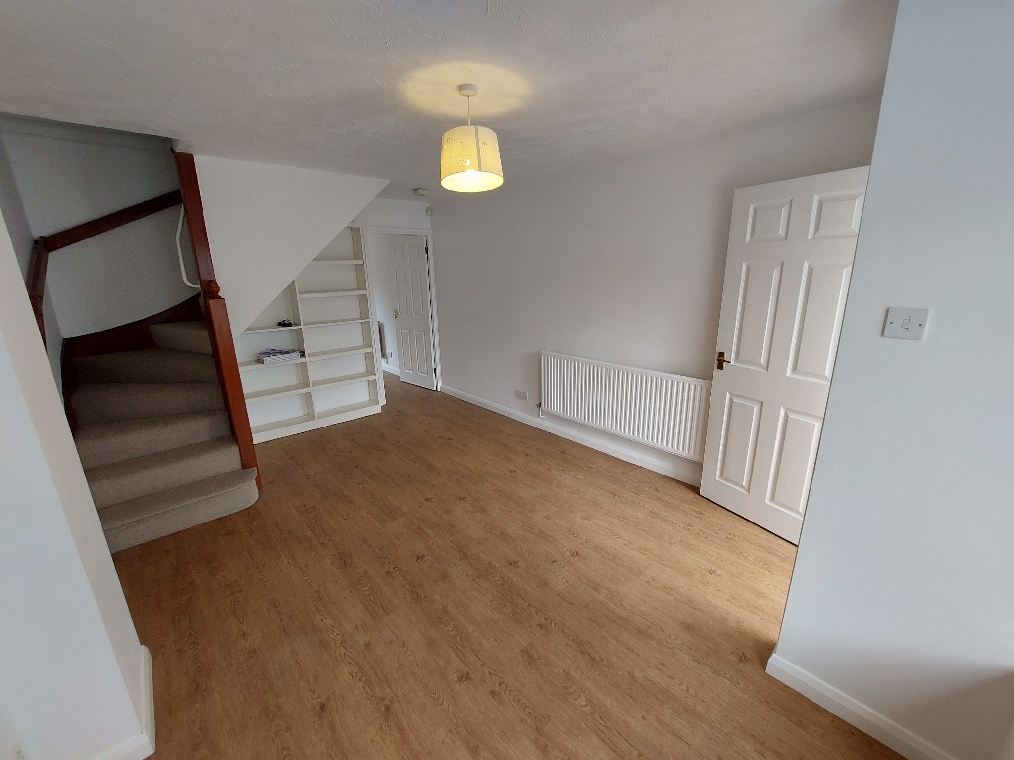 Finished white room with open staircase and new wood-effect floor