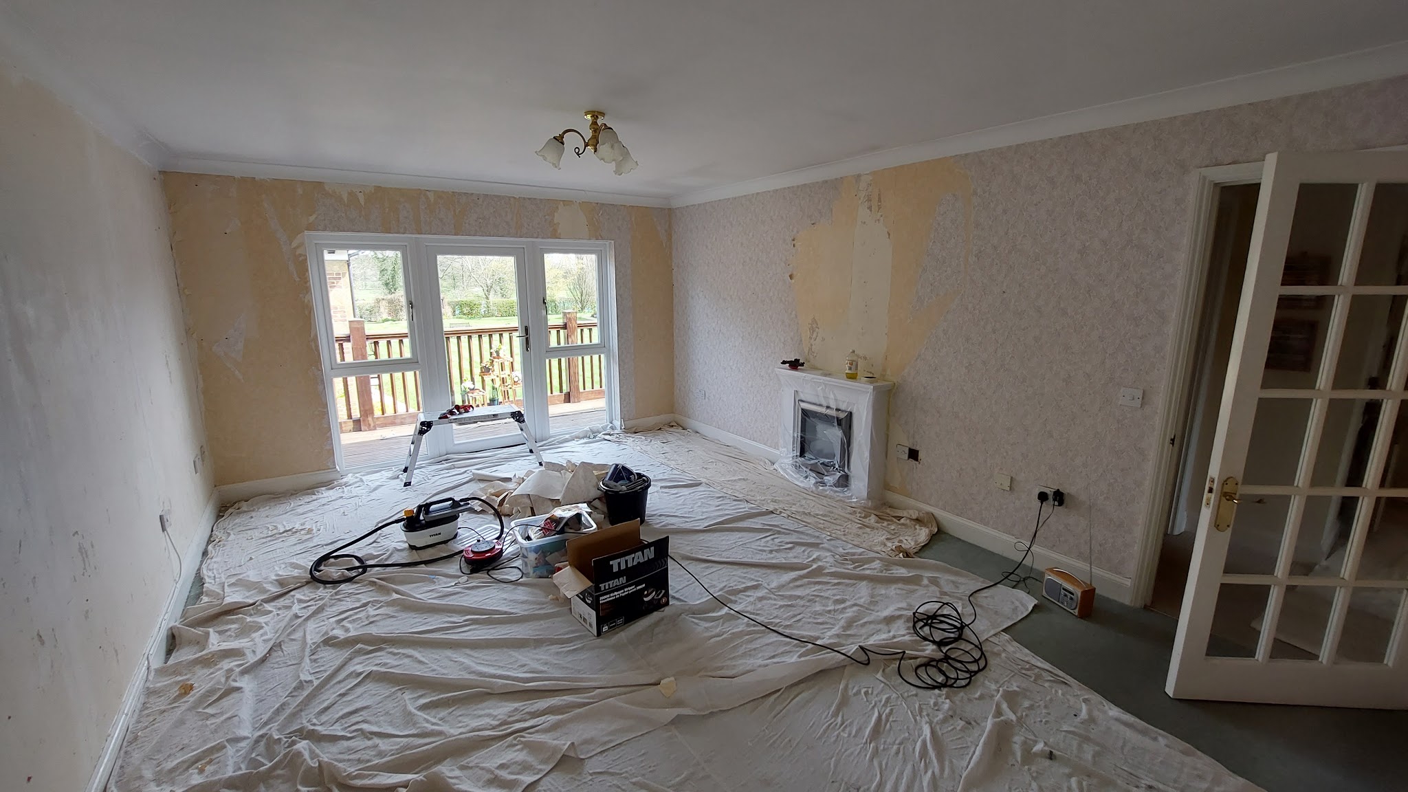 Living room stripped back and sheeted, ready for decorating