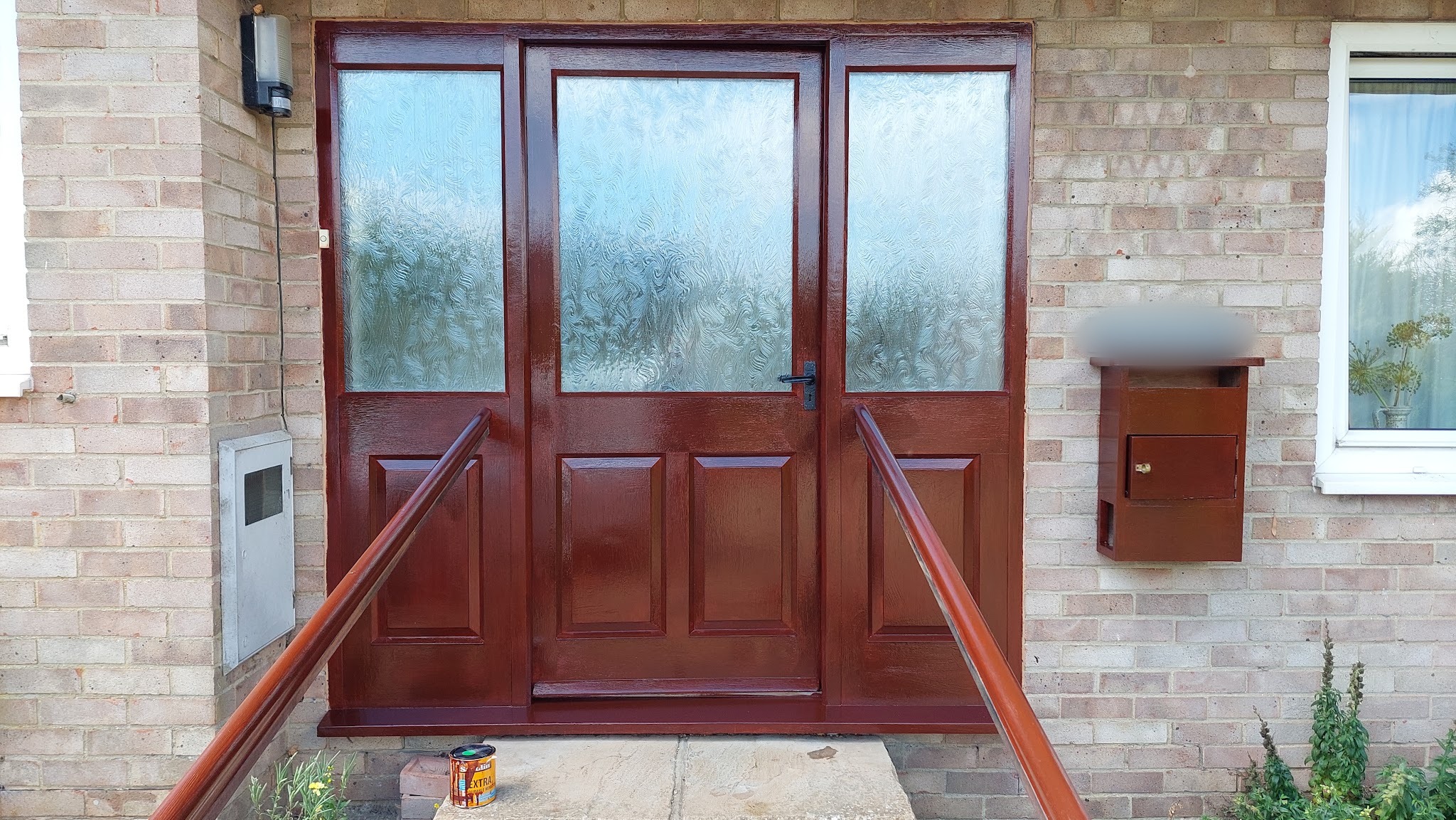 Glossy mahogany front doors and matching post box
